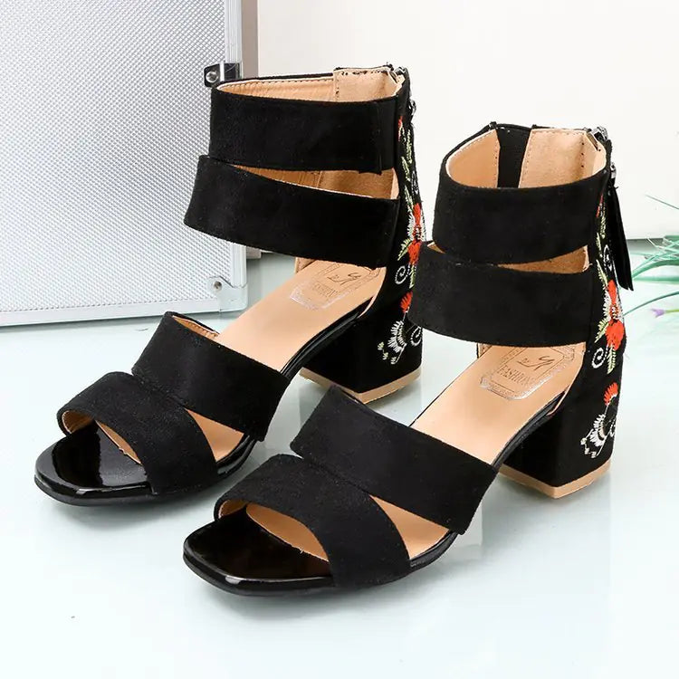 Pair of women's black sandals with floral embroidery on the thick block heel and open-toe design