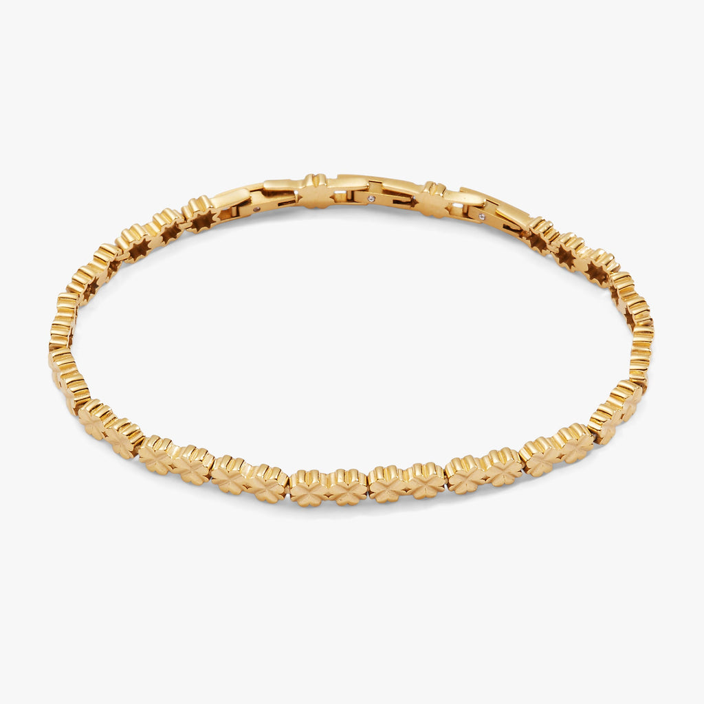 Gold-tone stainless steel tennis bracelet featuring inline four-leaf clover charms.