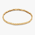 Gold-tone stainless steel tennis bracelet featuring inline four-leaf clover charms.