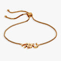 Gold-plated adjustable bolo bracelet featuring wishbone, clover, and horseshoe charms