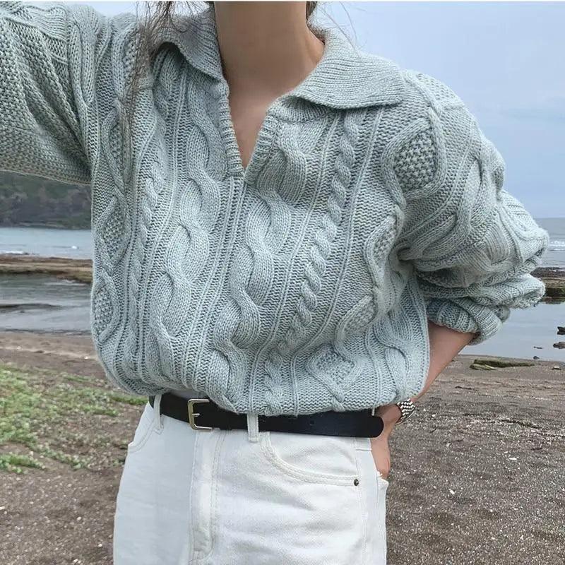 Woman wearing a loose light blue retro sweater with a turn-down collar.
