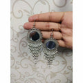 Long black stone jhalar drop earrings featuring an oxidized silver sun design.