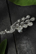 Close up of an oversized oxidised silver peacock statement ring worn by a woman