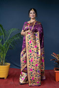 A luxurious wine-colored Paithani silk saree with fine zari weaving, displayed for an evening party look.