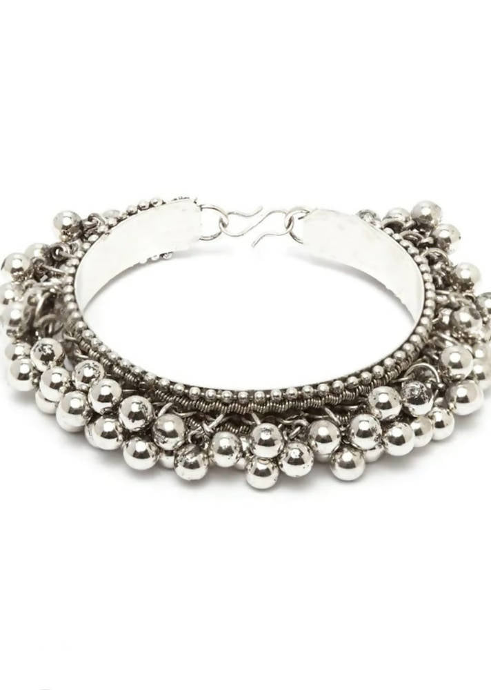 Handcrafted oxidised silver-plated ghungroo bracelet shown against a soft-focus background