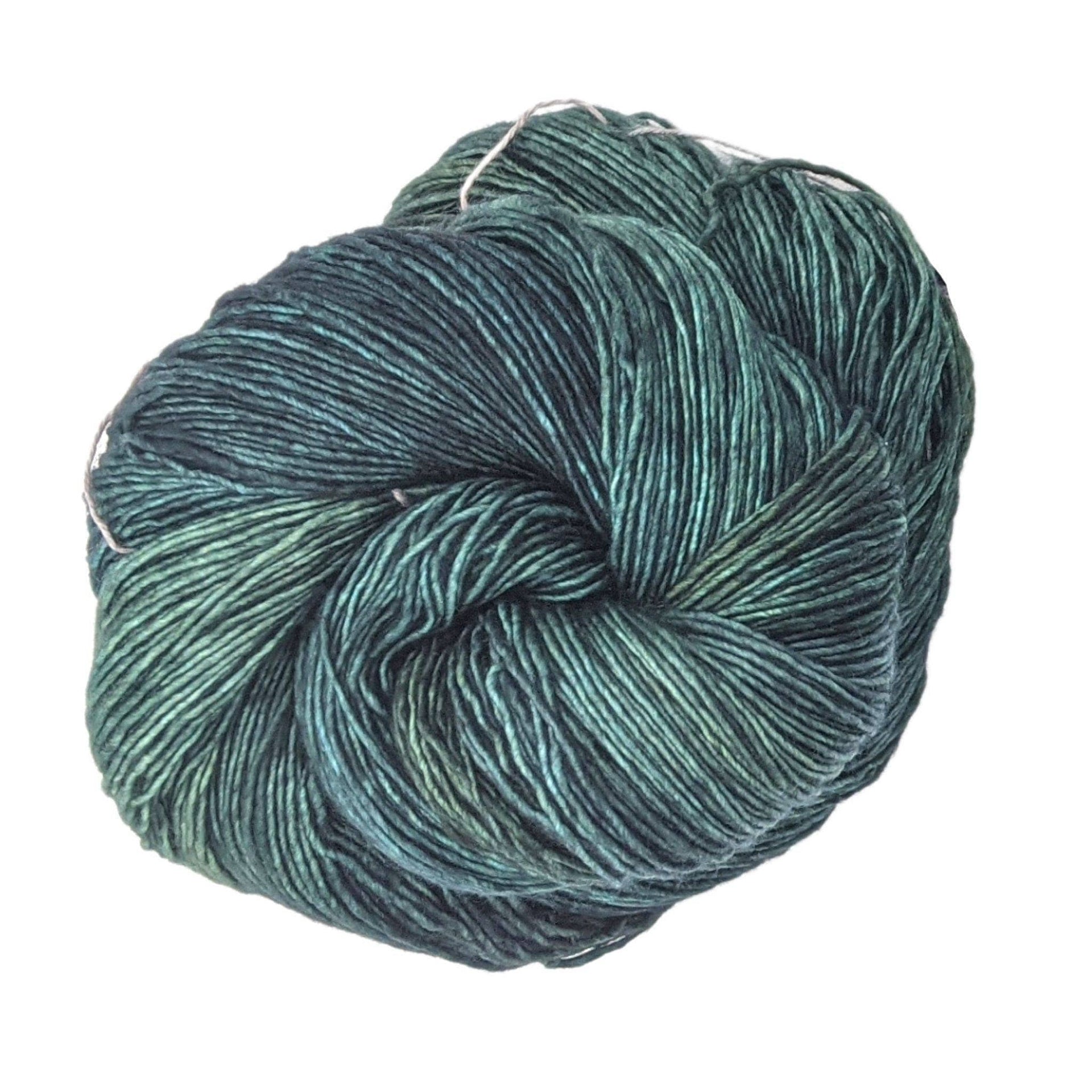 Skein of hand-dyed variegated multi-color Malabrigo Mechita superwash merino yarn for bohemian knit projects.