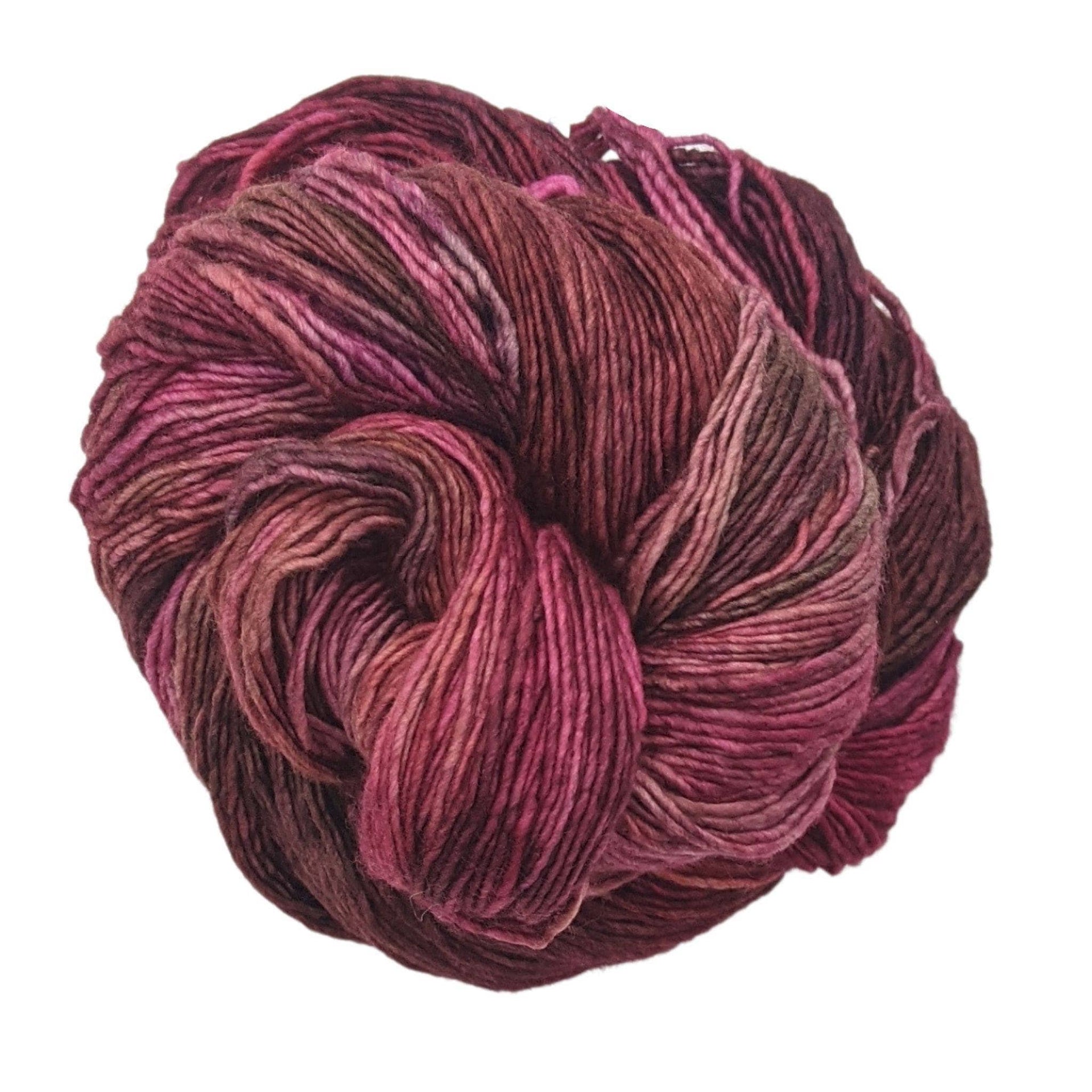 Skein of Malabrigo Rastita Merino Wool yarn in earth tone colors including rust, brown, and olive.
