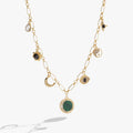 Gold-toned charm necklace featuring malachite stone, evil eye, yin-yang, and moon pendants