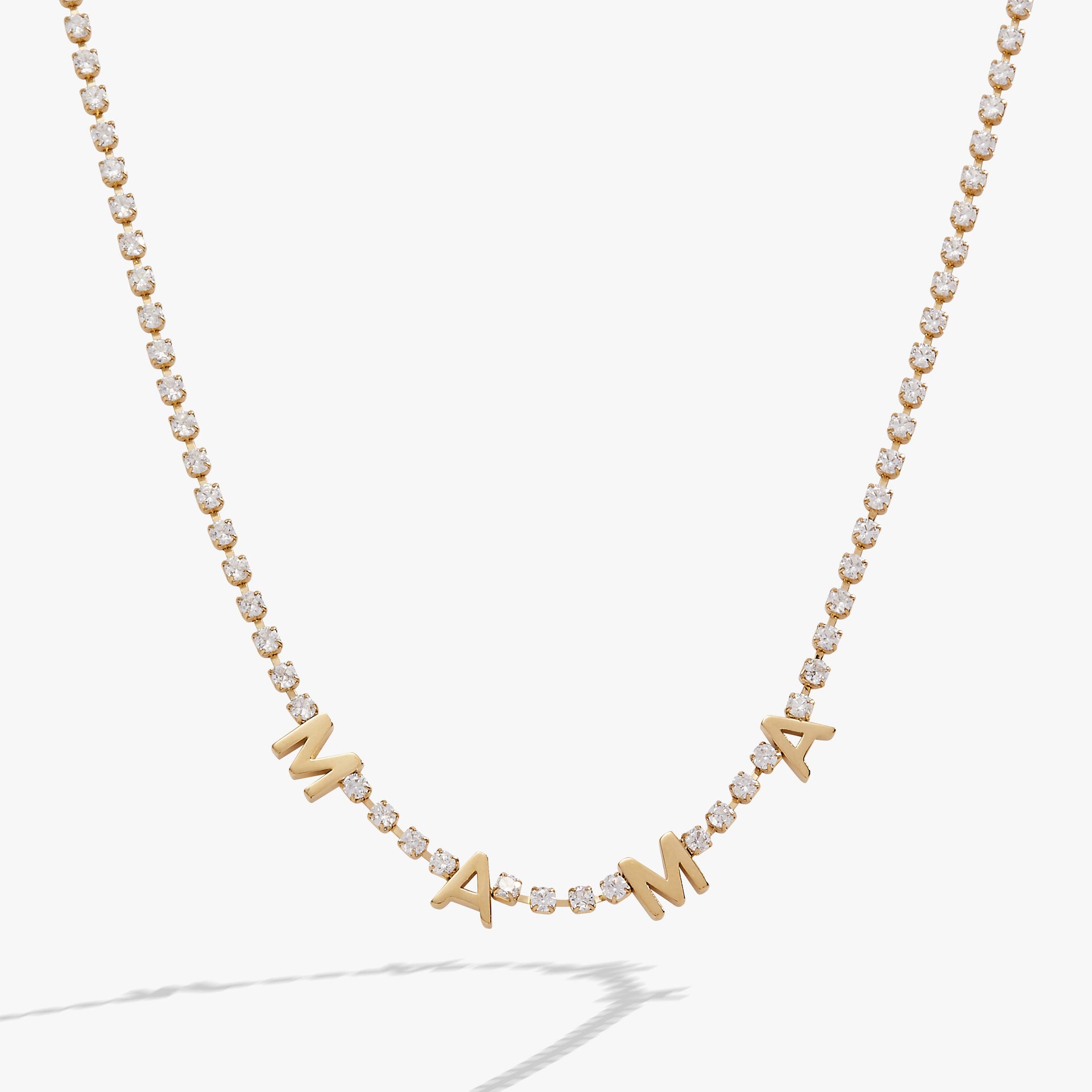 Close up of the Mama Crystal Tennis Necklace on a white background, highlighting crystal chain and MAMA lettering.