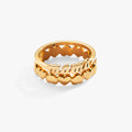 A two-piece stackable gold ring set featuring a script Mama ring and an alternating heart pattern band on a white background.