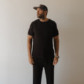 Men wearing a black ribbed bamboo short sleeve pajama set with full-length pants.