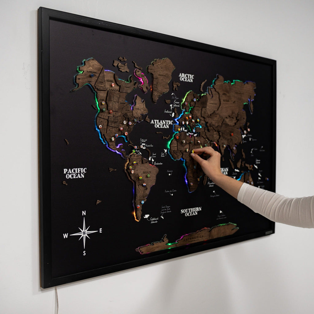 Large Dark Walnut LED world map on a black background mounted in a modern living room