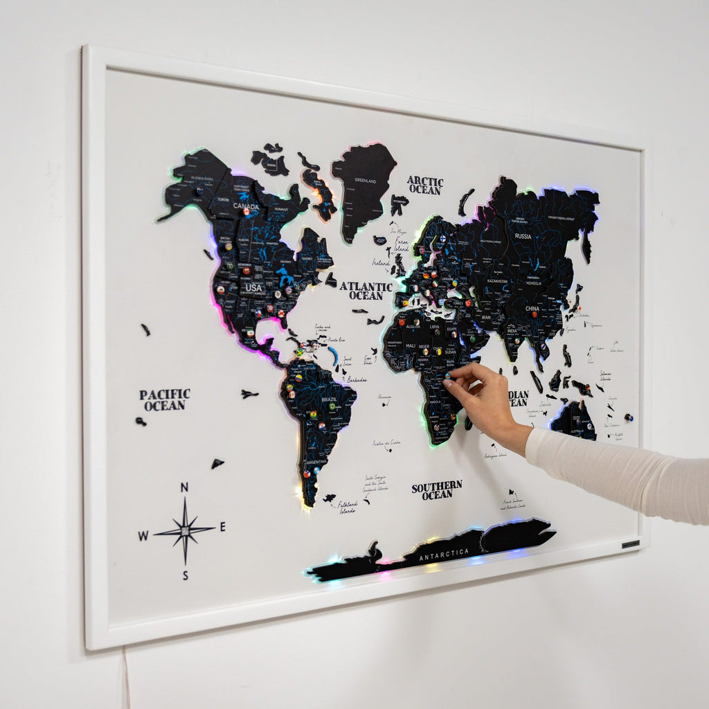 Modern minimalist black and white LED illuminated world map on a living room wall