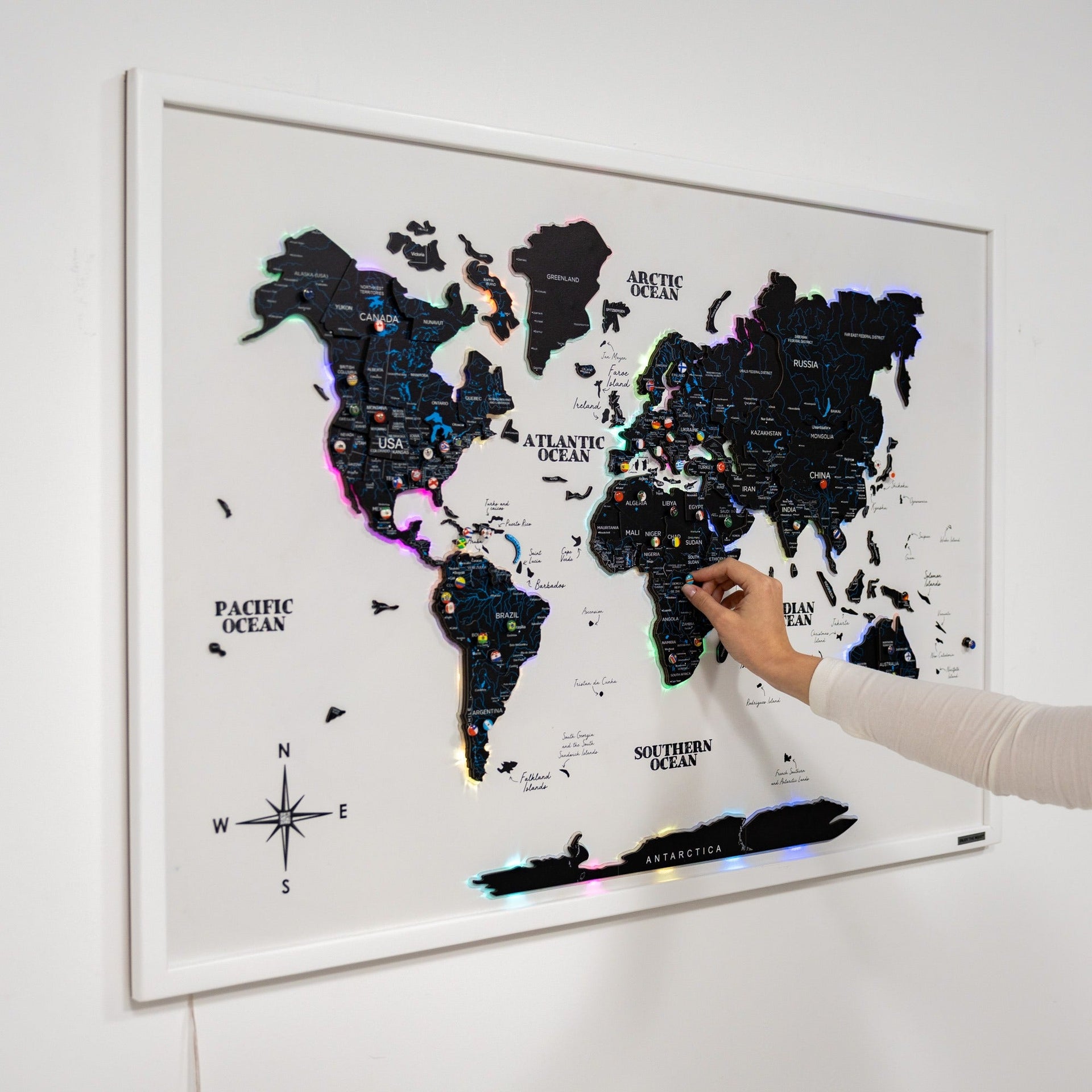 Modern minimalist black and white LED illuminated world map on a living room wall