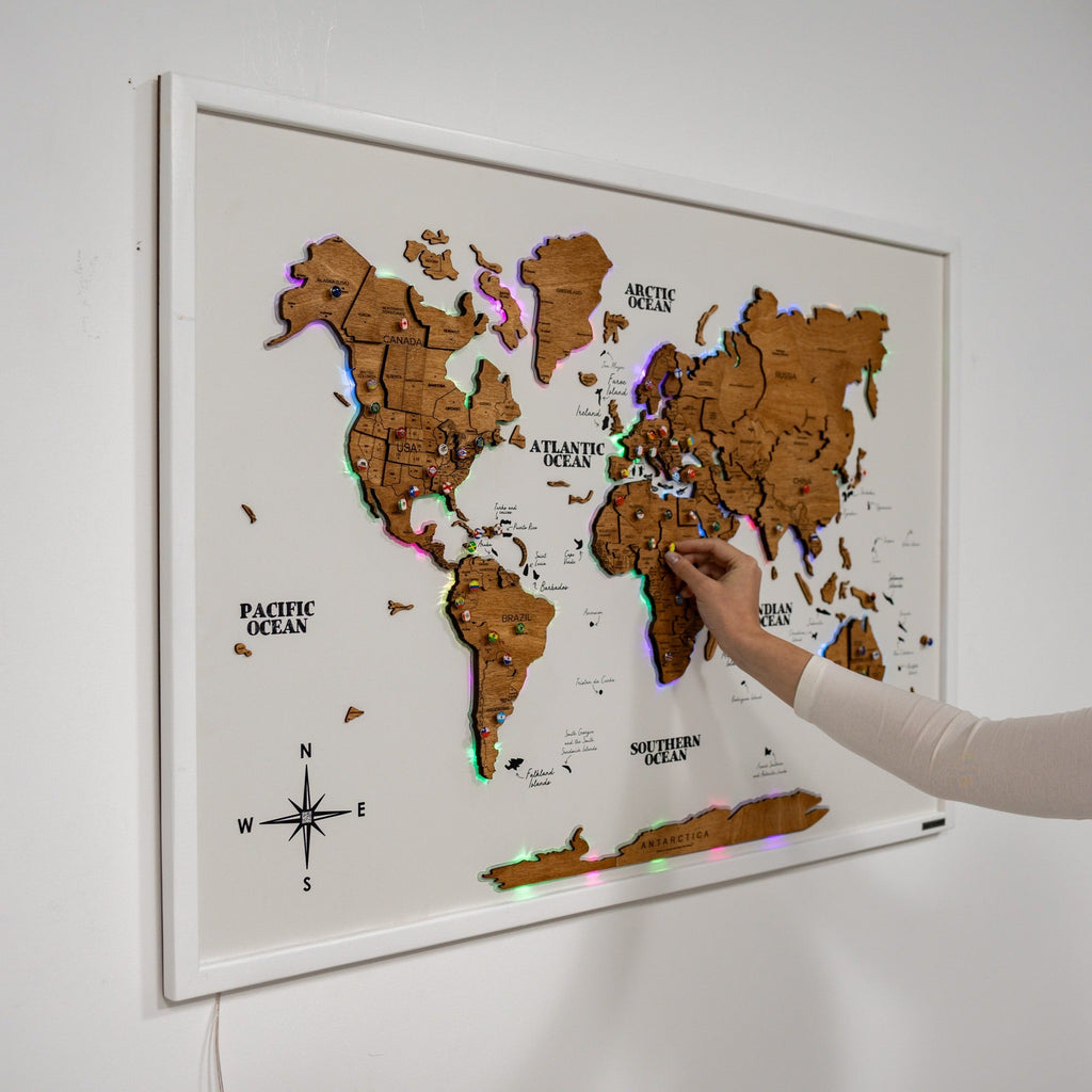 Large wooden world map wall art with LED lighting in an oak finish mounted on a modern living room wall.