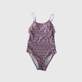 Woman wearing a flattering pink and lavender one-piece swimsuit at the pool