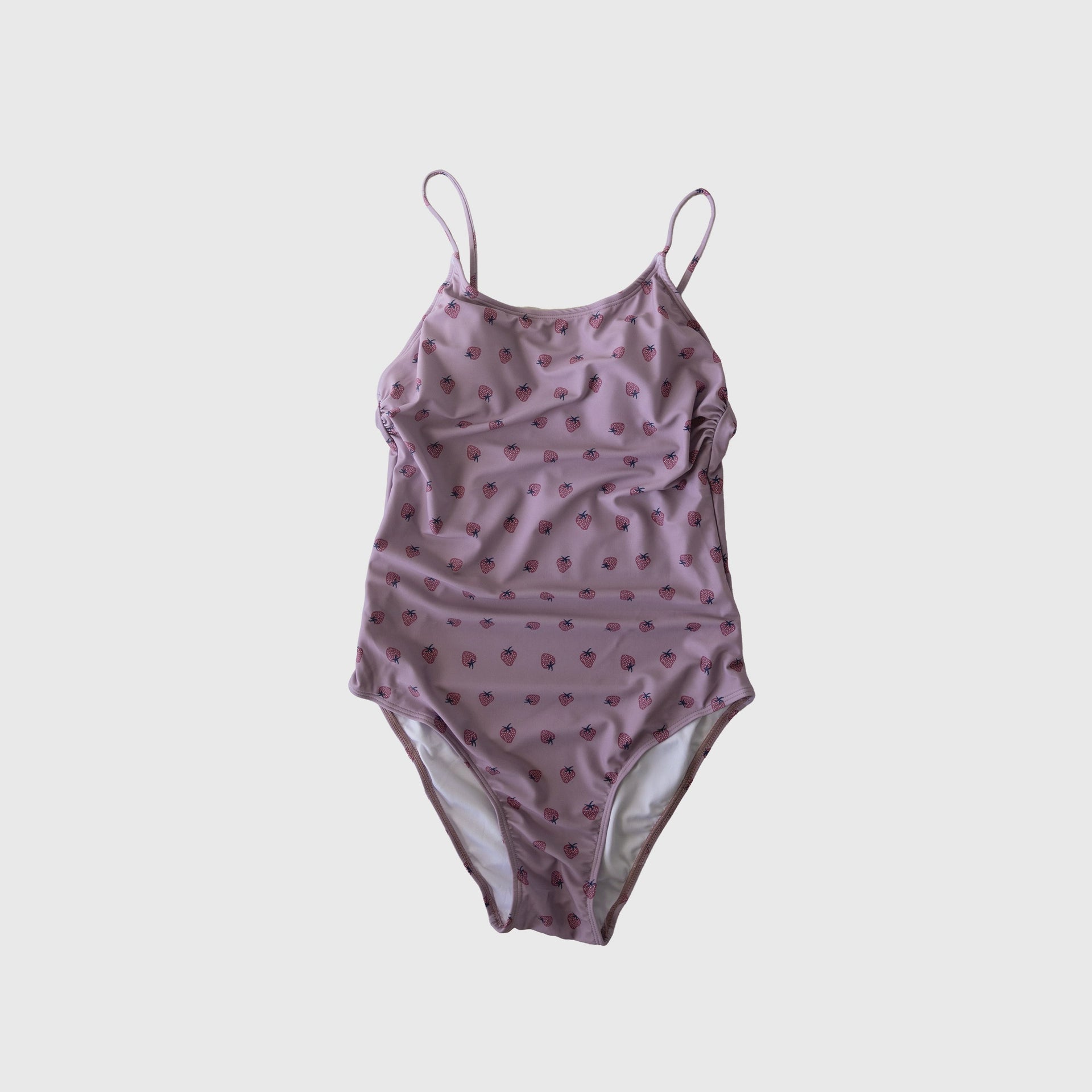 Woman wearing a flattering pink and lavender one-piece swimsuit at the pool