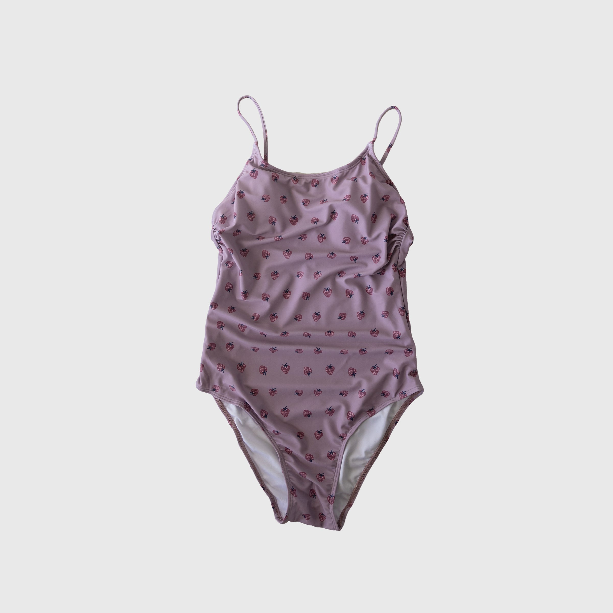 Woman wearing a flattering pink and lavender one-piece swimsuit at the pool