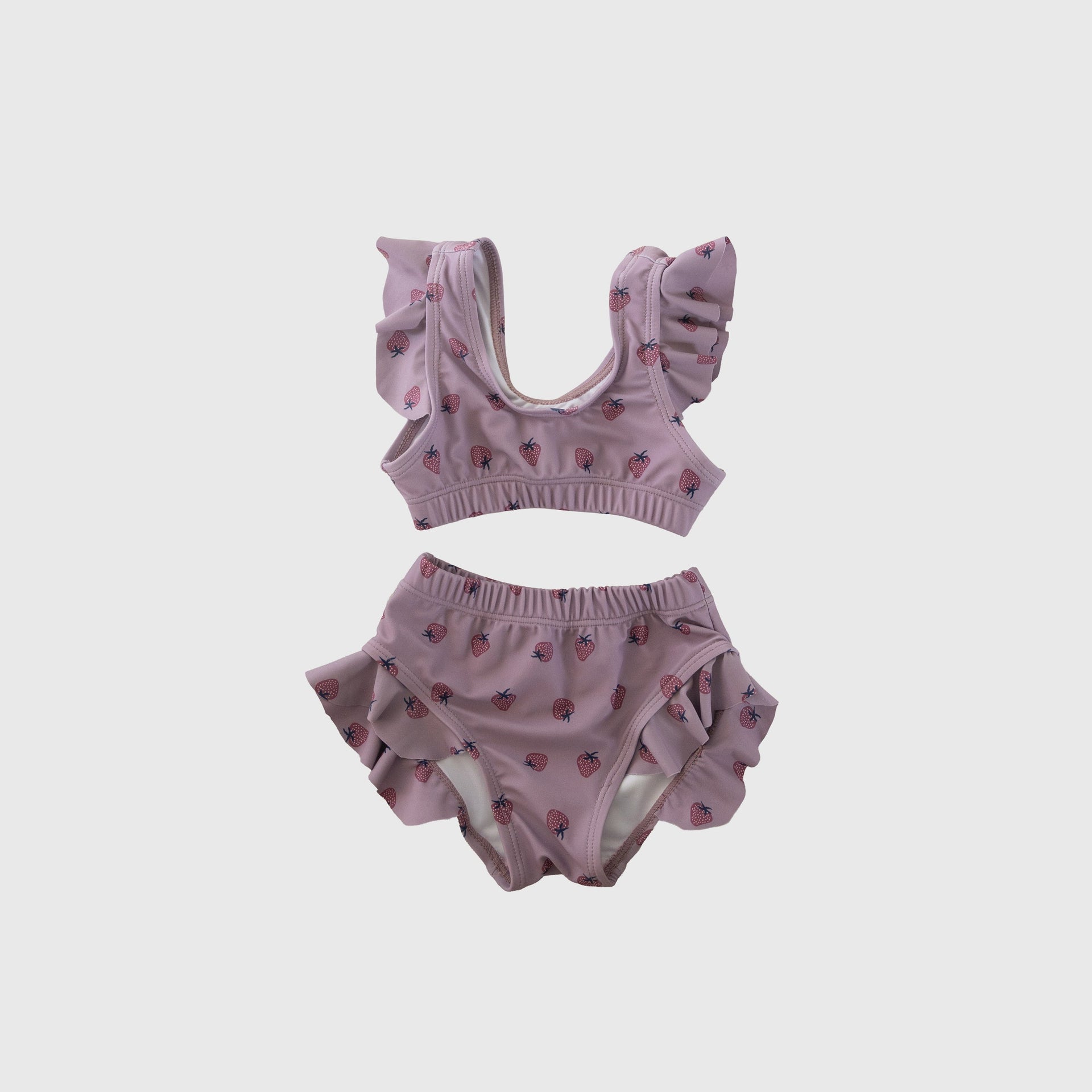 Girl wearing a two-piece Matilda swimsuit with a pink strawberry pattern