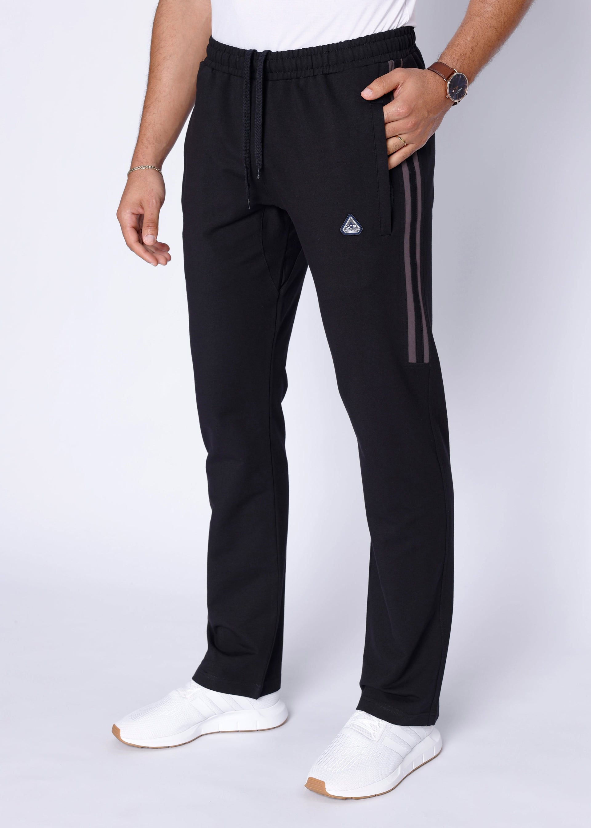 A man wearing black athletic straight-leg sweatpants from the front and back views.