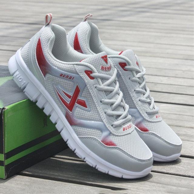 Men's lightweight grey, blue, red, and white mesh running sneakers with honeycomb cushioned insoles.