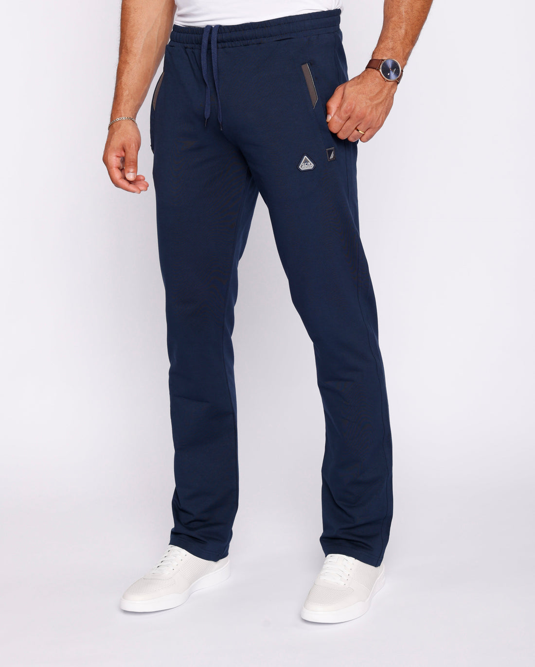 A man wearing navy blue athletic sweatpants with a straight-leg fit and adjustable drawstring waist.