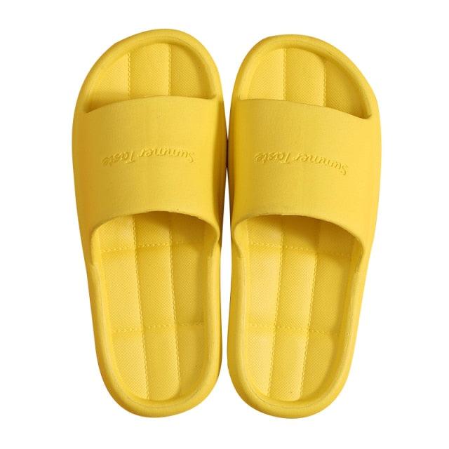 A pair of minimalist unisex non-slip EVA shower sandals in bright yellow, teal, orange, and black.