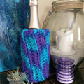 Handcrafted mermaid-themed wine bottle sleeve made with a textured knit and crochet pattern.