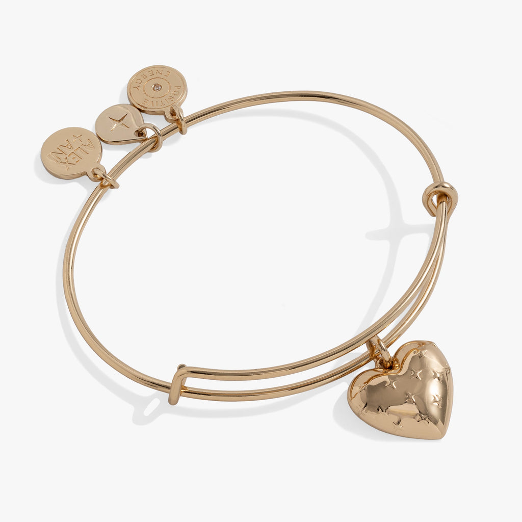 Gold-toned expandable wire bangle featuring a heart charm with starburst detailing.
