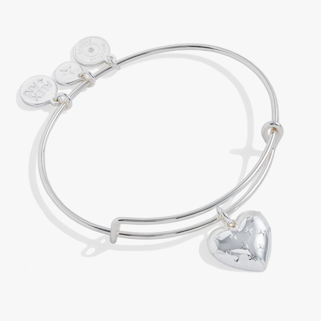 Silver tone expandable bangle featuring a heart charm with starburst engraving on a white background.