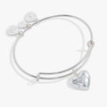 Silver tone expandable bangle featuring a heart charm with starburst engraving on a white background.