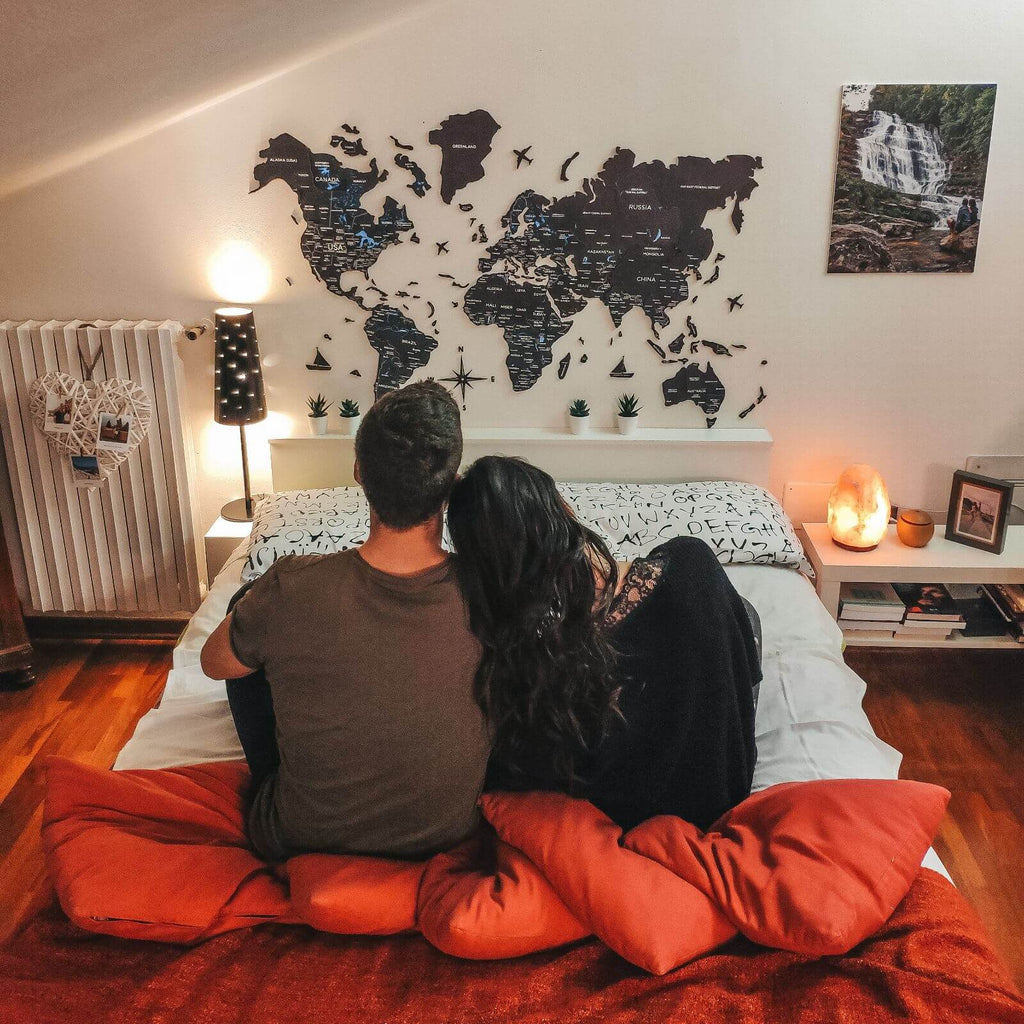 3D Wooden World Map Midnight in charcoal and midnight-blue hues mounted on a modern wall.