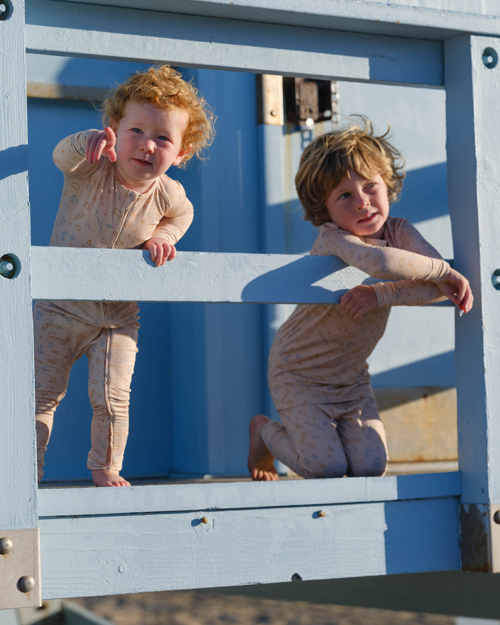 Two children playing on a playground structure with a mirror.