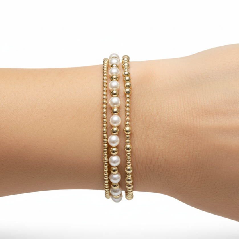 Three-piece Miss Duchess bracelet stack featuring gold beads and white pearls on a woman's wrist