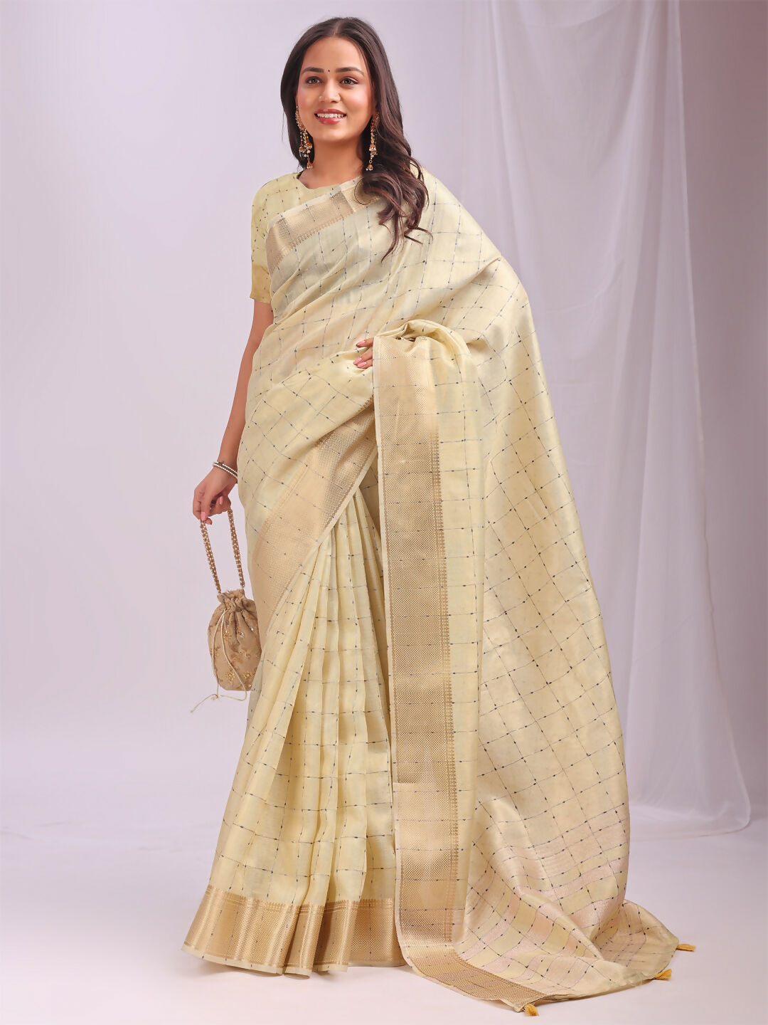 Elegant gold organza saree featuring a yellow blouse, perfect for festive events.