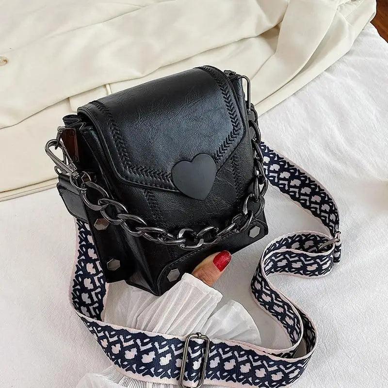 Modern elegant heart-shaped shoulder bag with studded detailing