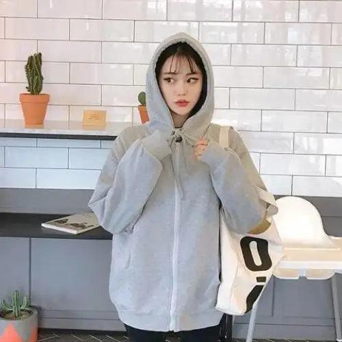 Oversized women's zip-up hoodie in solid color with kangaroo pocket and hood