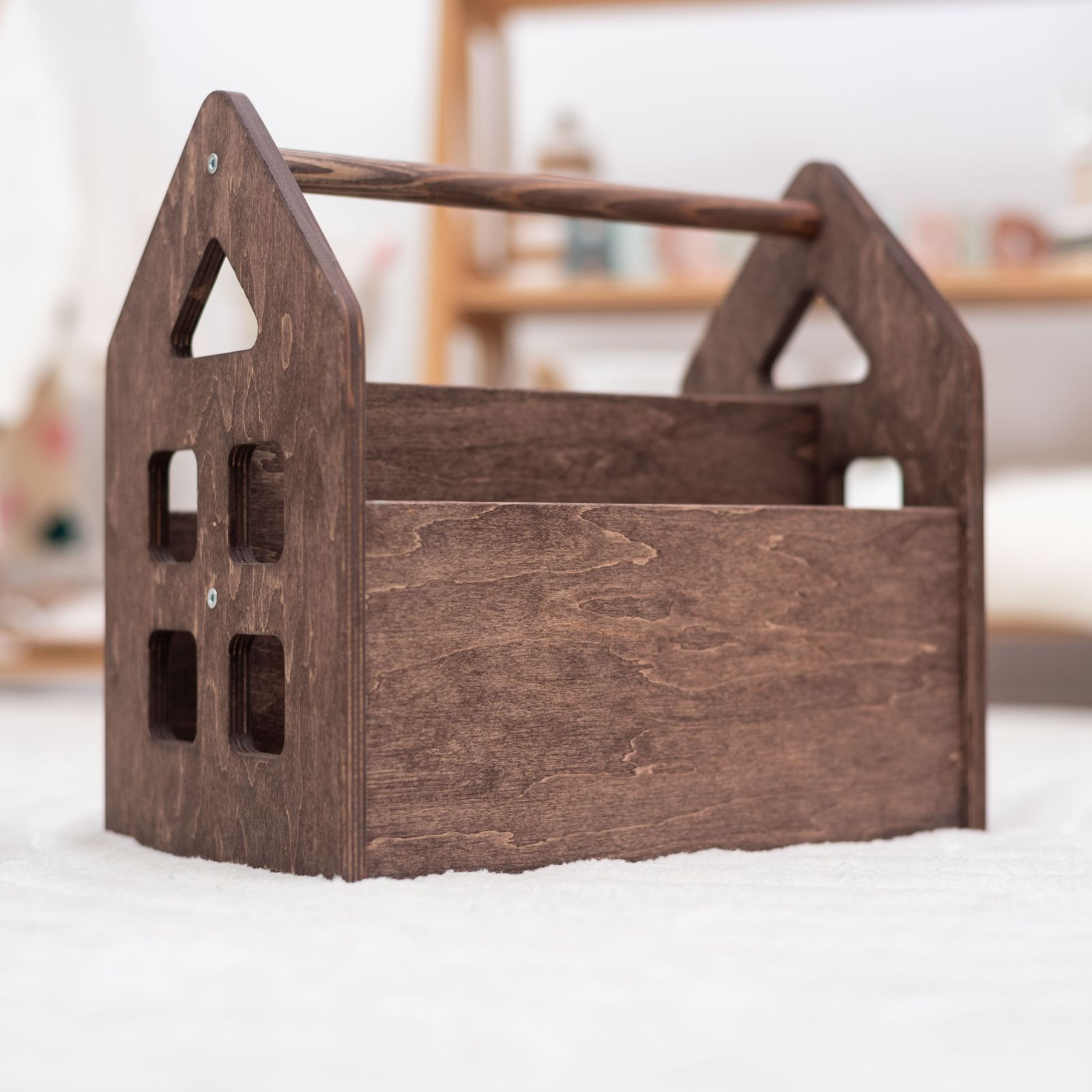 Dark walnut Montessori front-facing bookshelf in a cozy nursery setting