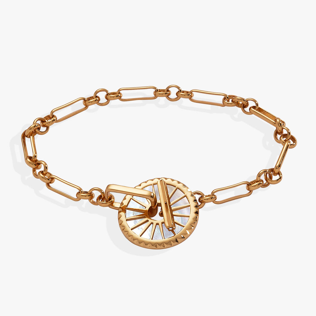 Gold open-link chain bracelet with a mother of pearl starburst charm and toggle clasp