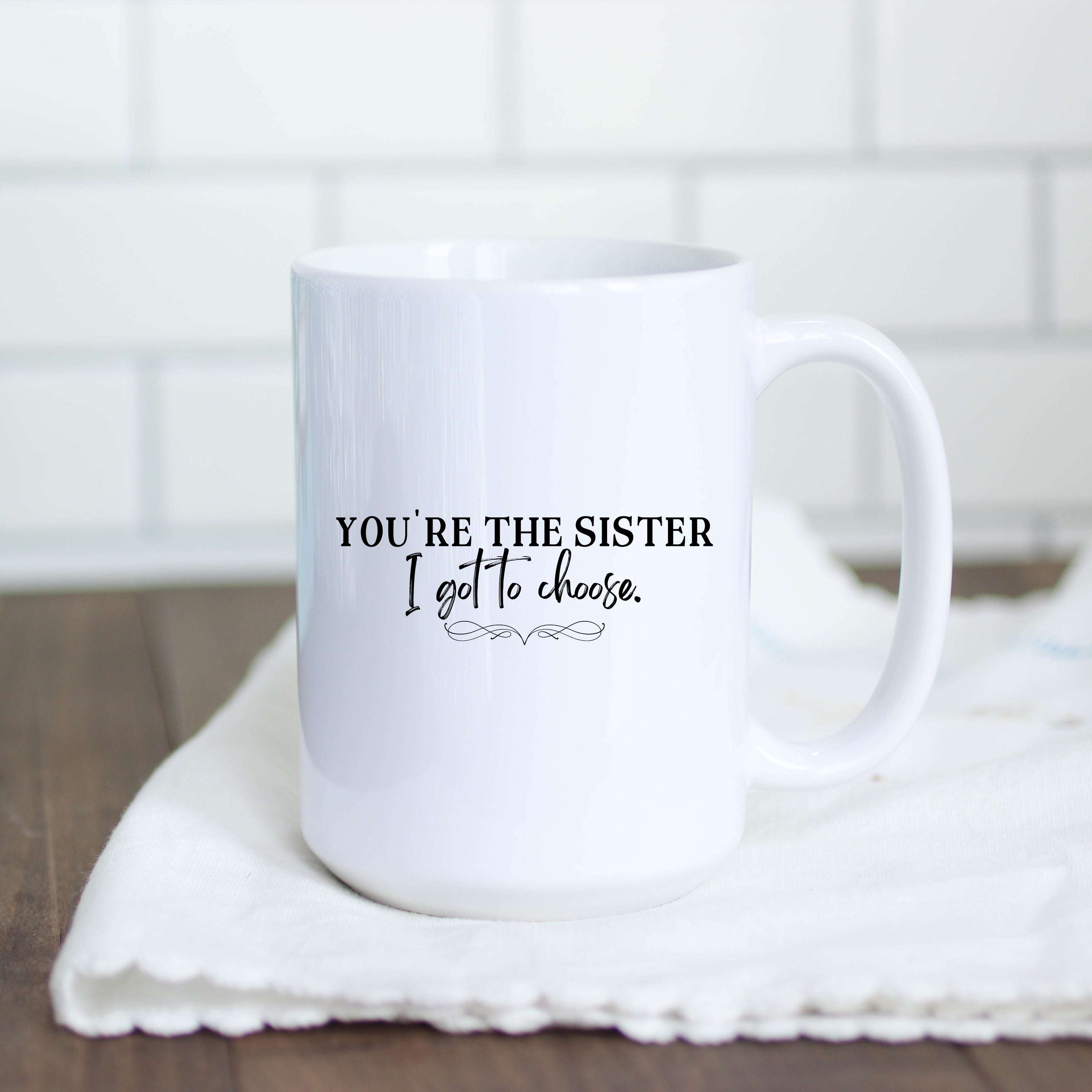White 15oz ceramic mug with the text You're the Sister I Got to Choose in black lettering.