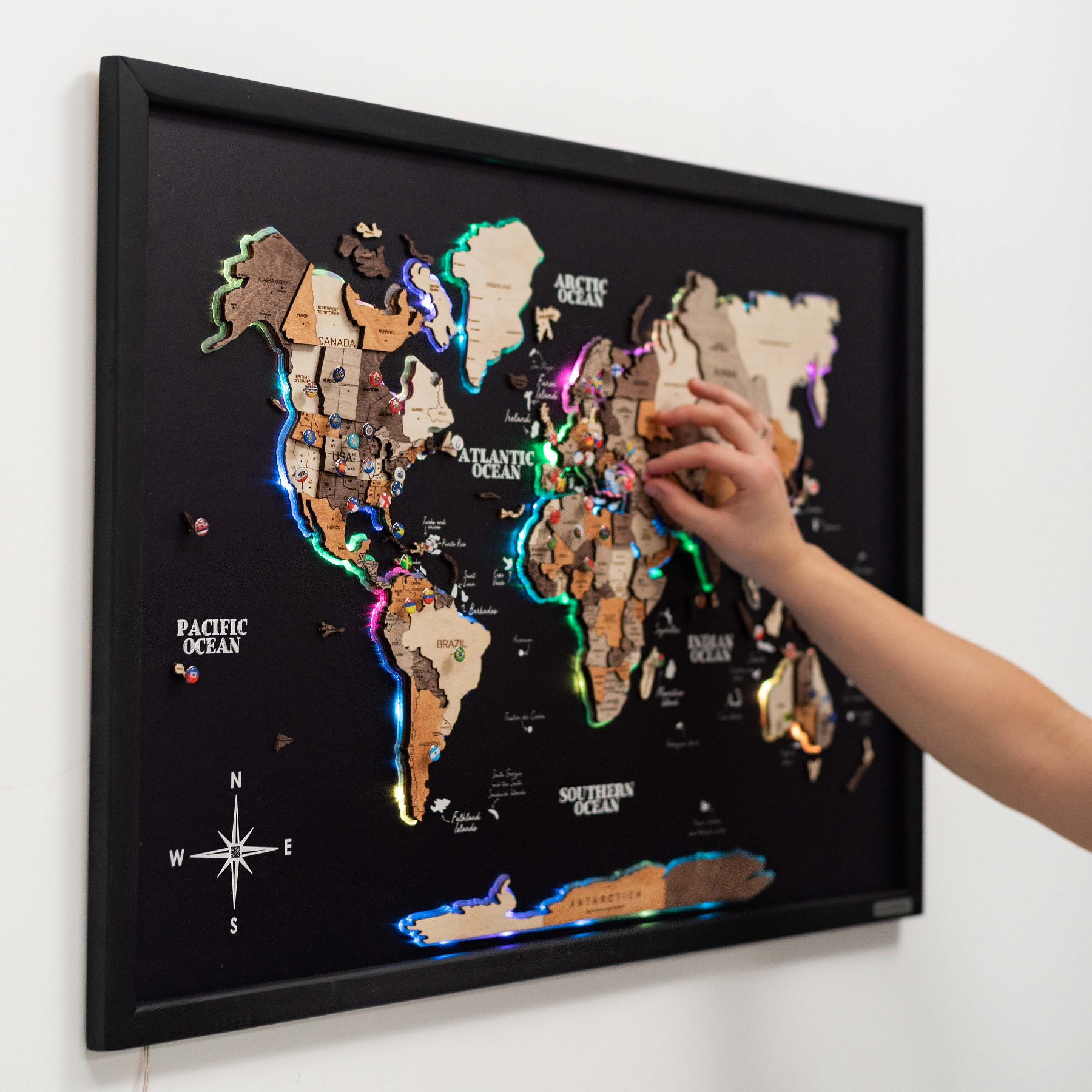 Interactive cork world map with multicolor LED lighting glowing on a wall
