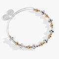 Silver mushroom beaded bangle with gold spacer beads on a studio background.