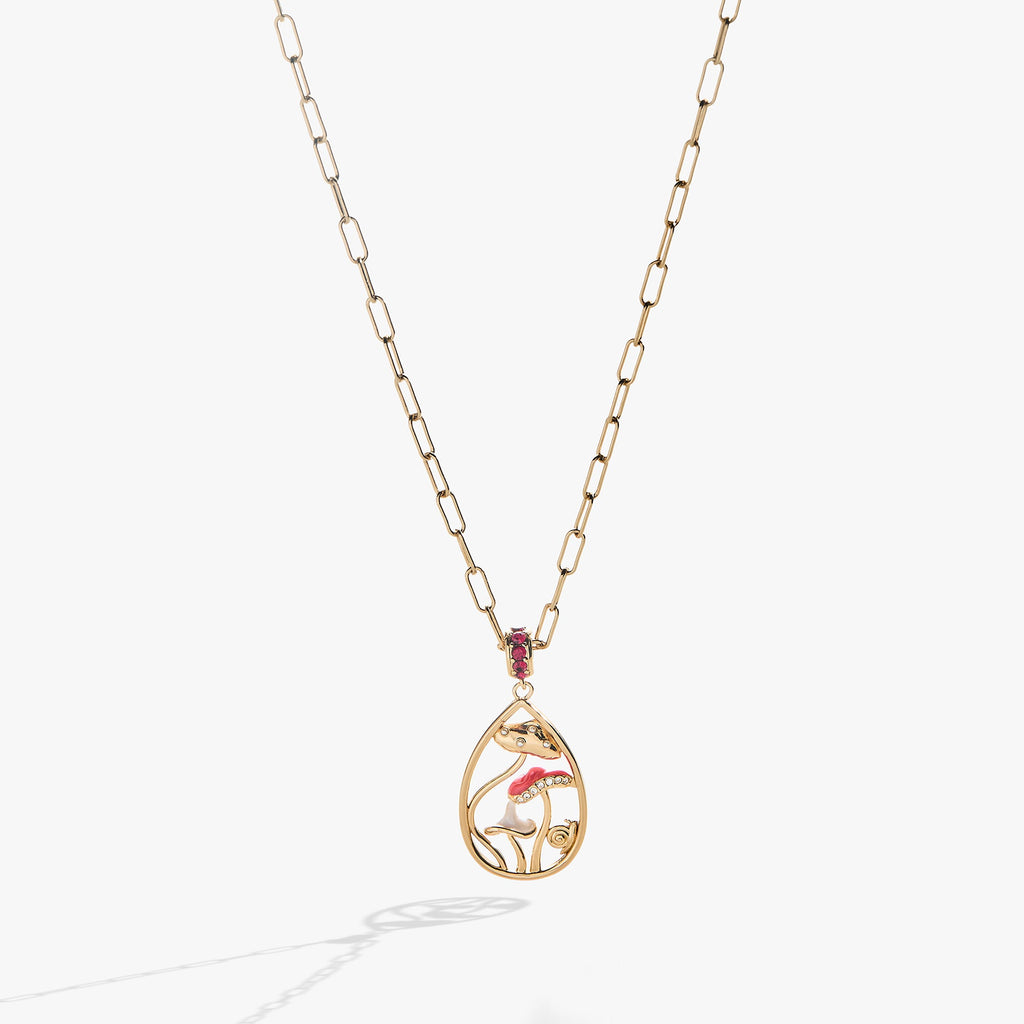 Gold circle pendant necklace featuring whimsical mushroom charms and a ruby-red crystal accent ring