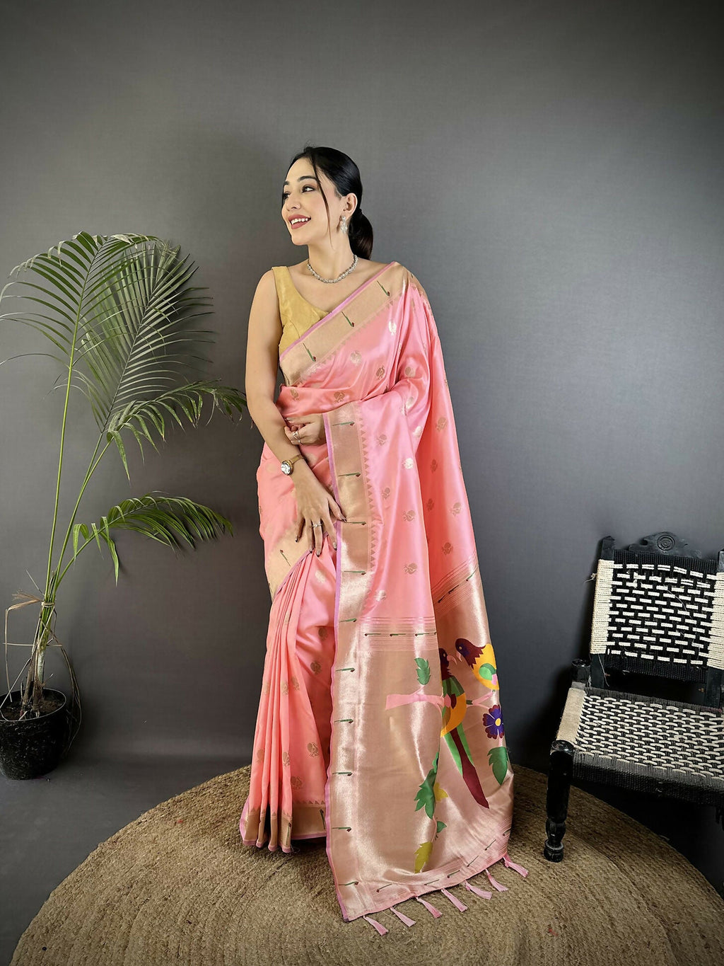 Light pink soft silk Kanchipuram saree with detailed peacock and floral motifs and matching blouse piece.