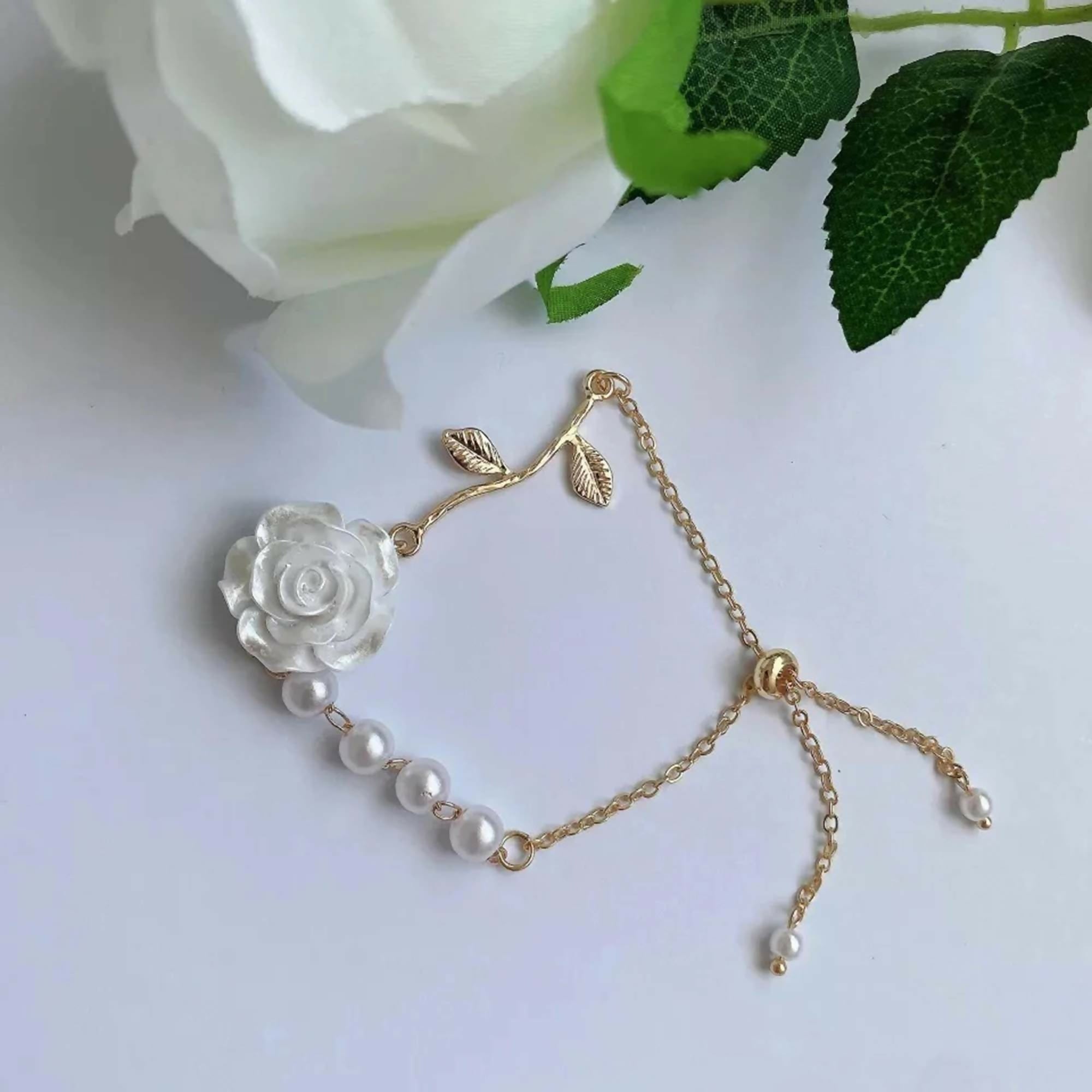 White rose floral design bracelet crafted in brass, showcased on a neutral background.