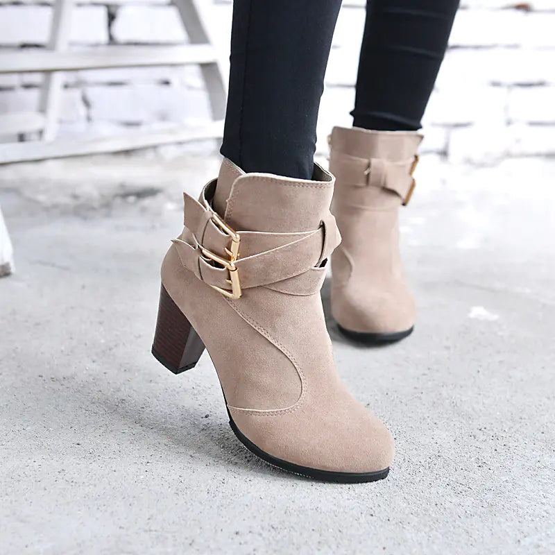 Women wearing beige suede ankle boots with chunky heels and gold buckle details