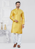 Men wearing a bright yellow printed jacquard silk kurta and pyjama set for a festive occasion.