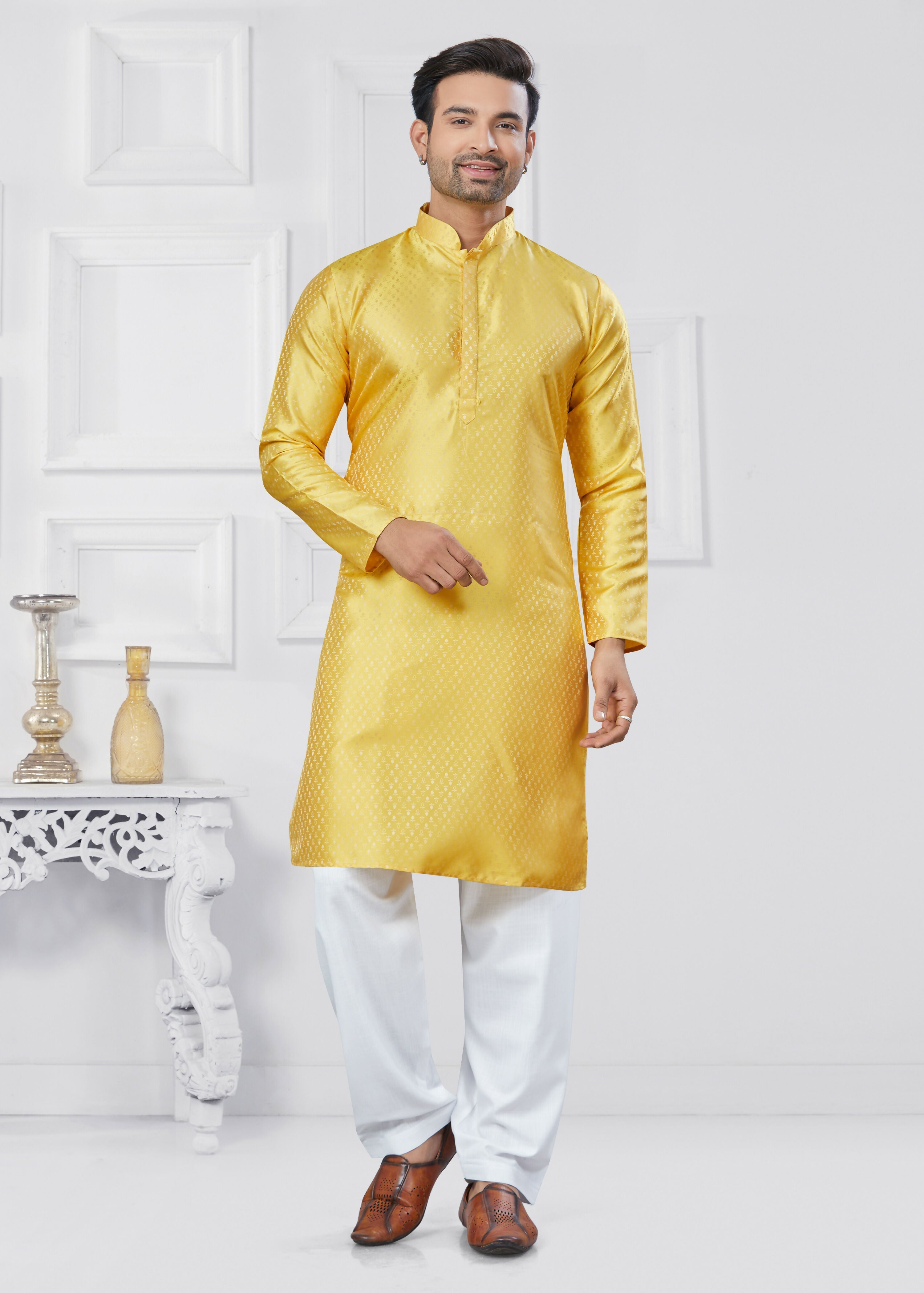 Men wearing a bright yellow printed jacquard silk kurta and pyjama set for a festive occasion.