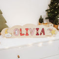 Personalized wooden cloud name puzzle on a nursery shelf