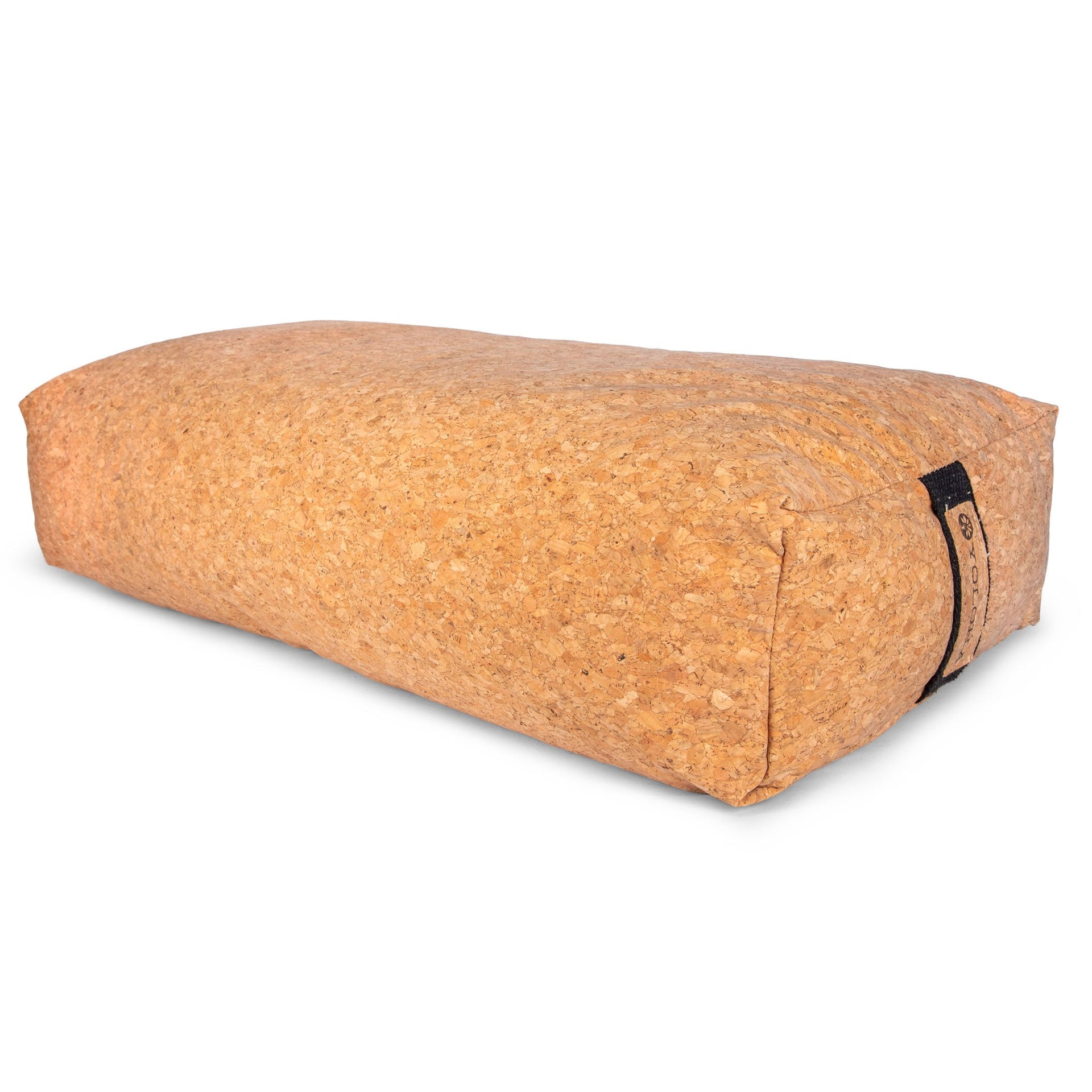 A sustainable cork bolster in natural cork brown resting in a minimalist living room setting.